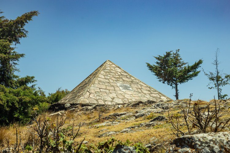 A pyramid on a mountain where we observe stones on the ground.