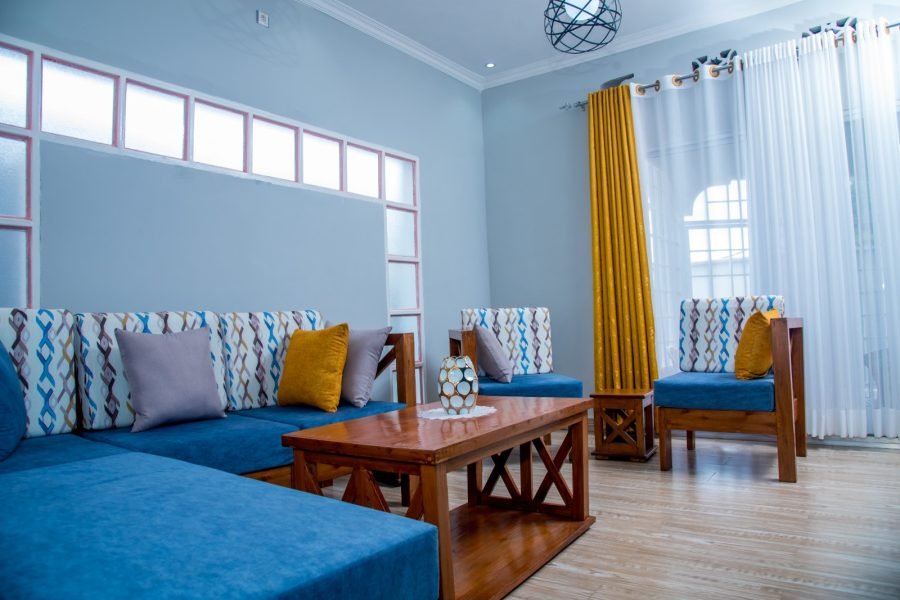 a room with blue couches and a table in a house for rent in Burundi