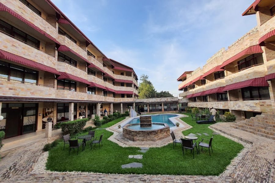 a pool and chairs in the courtyard of Roca Golf Hotel in Bujumbura, Burundi